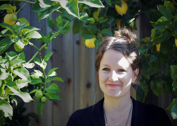 Bess Dallal, L.Ac., standing under a lemon tree